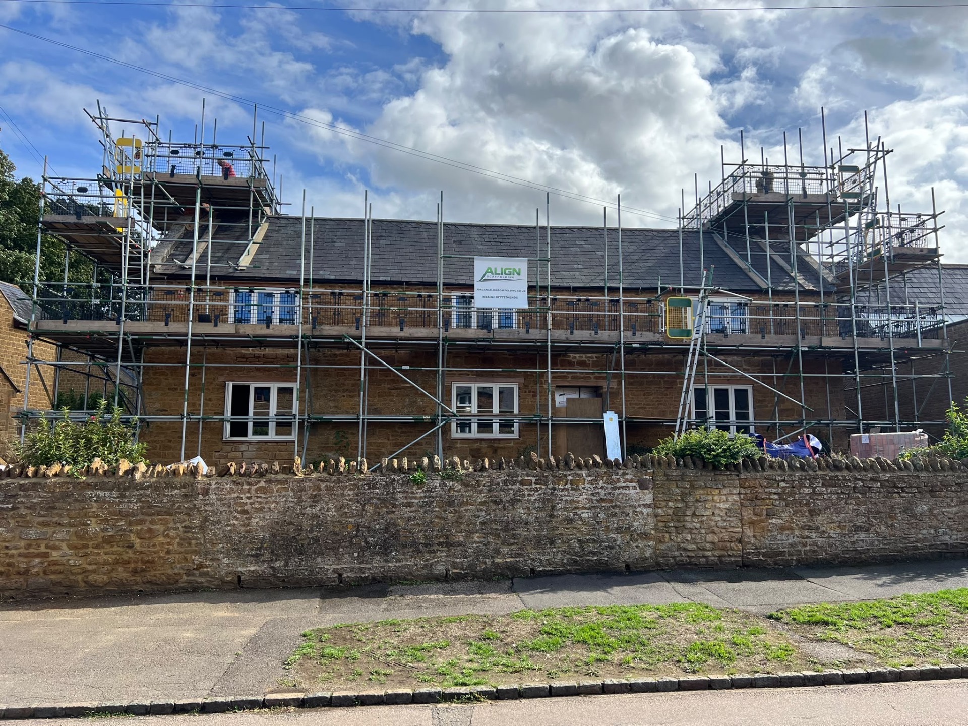 Align Scaffolding erection around a stone cottage with the Align banner in place